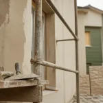 Solutions rénover ou embellir façade : mur en rénovation avec enduit et peinture sur échafaudage