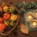 Décoration d'automne fait maison : photophores sur table bois, mini potimarrons et feuilles